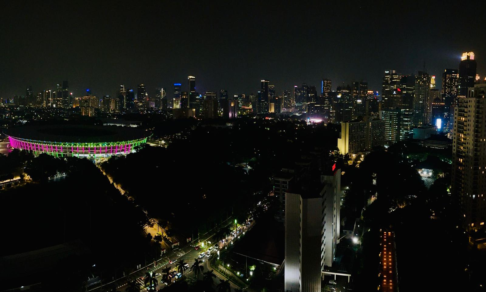 Jakarta skyline at night with the illuminated national stadium